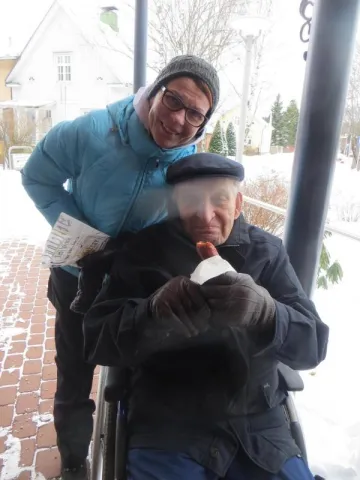 Muistihoitaja ja vanhus poseeraavat kameraan