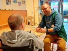 mies auttaa asiakasta syömään